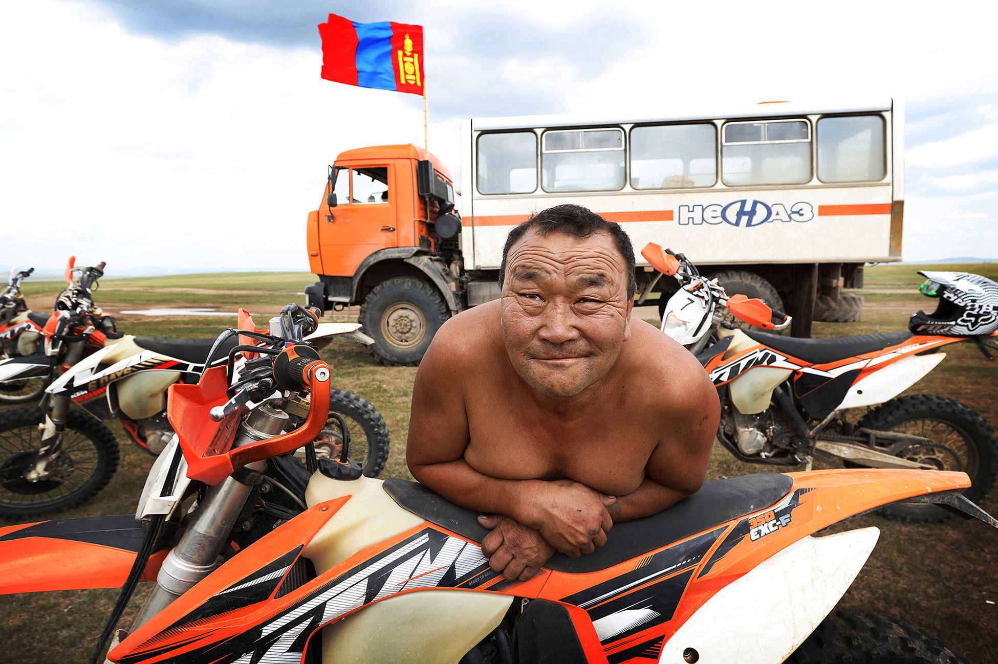 Portrait of a Mongolian man leaning on a motorbike as part of a 20 day motorbike trip across Mongolia
