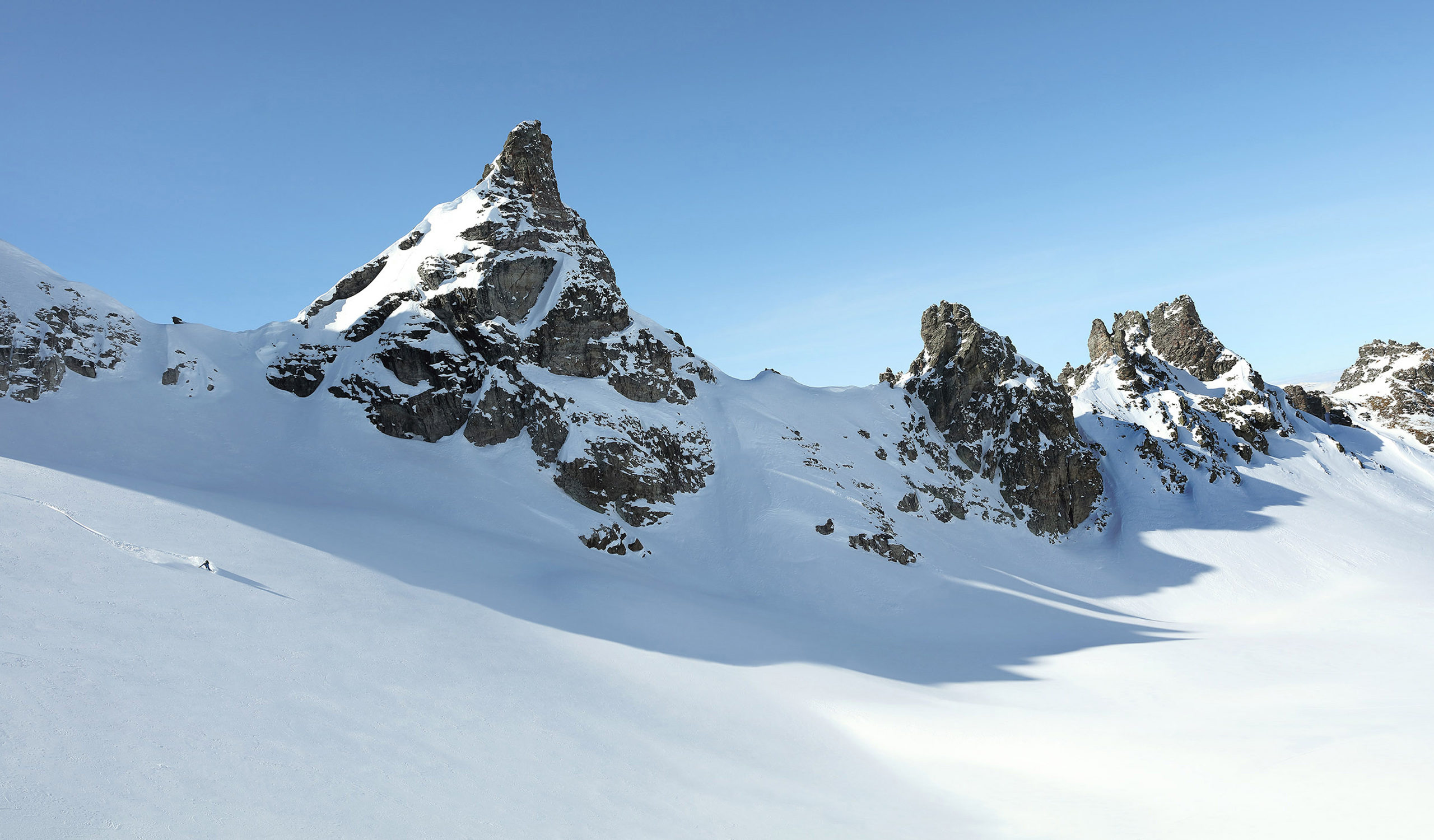 Reiten im Pulverschnee an einem schönen Tag in den Schweizer Alpen. Freeriden ist in der Schweiz sowohl bei Snowboardern als auch bei Skifahrern beliebt.