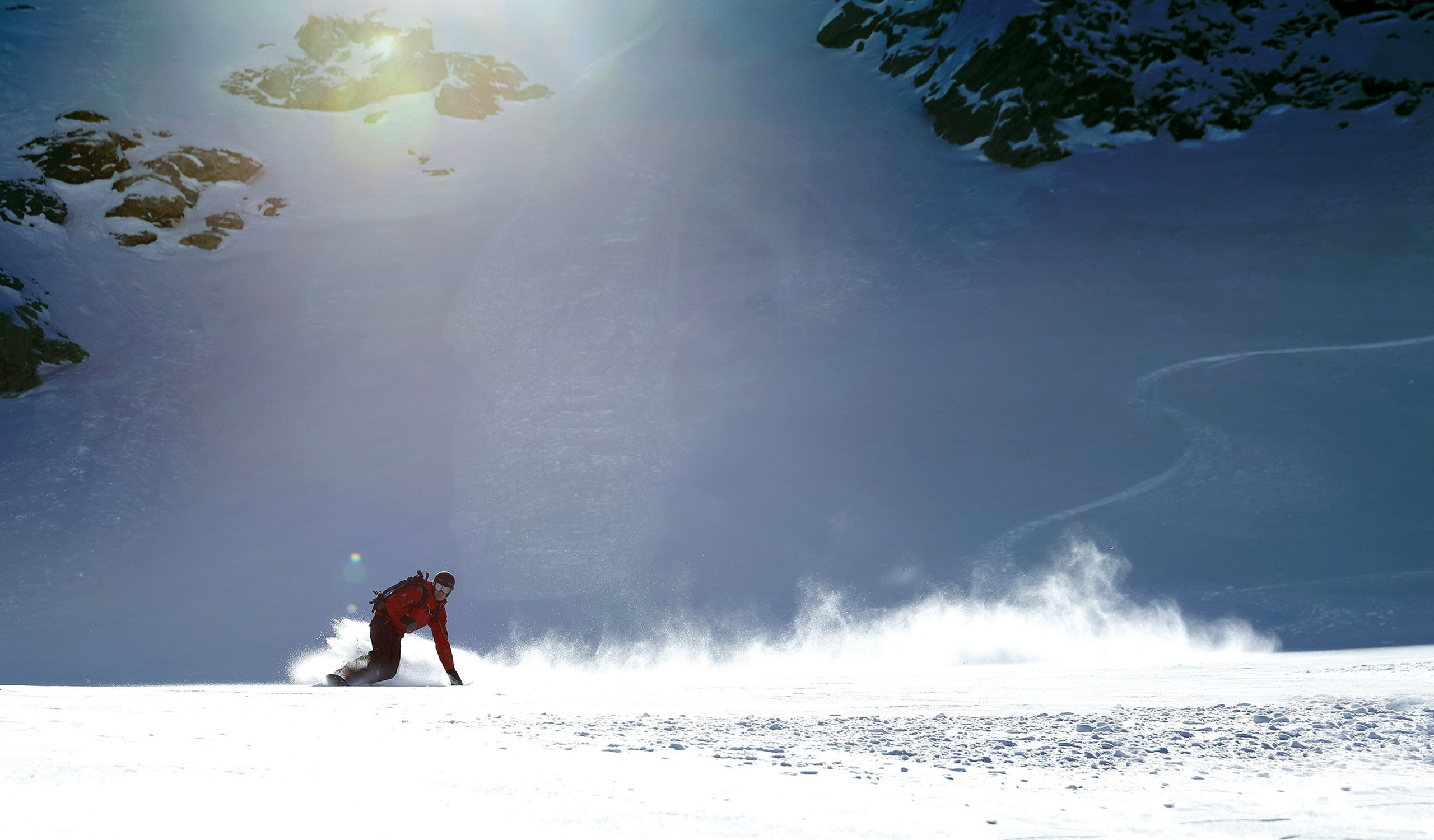 Snowboarden in der Schweiz. Der Wintersport ist in den Schweizer Alpen sehr beliebt. Snowboarder und Skifahrer durchqueren das Hinterland auf der Suche nach Abenteuer. Es gibt Zeiten im Winter, in denen die Berge vom Abenteuer sprechen. Der Wind weht warm aus dem Süden, um die kommenden Veränderungen anzukündigen, die Sonne verweilt noch ein wenig länger, aber dennoch schenkt der Himmel in seiner sanften Liebenswürdigkeit diesen Ländern einen frischen Spritzer unberührten Pulvers. Dies sind die Tage des Zuckers.