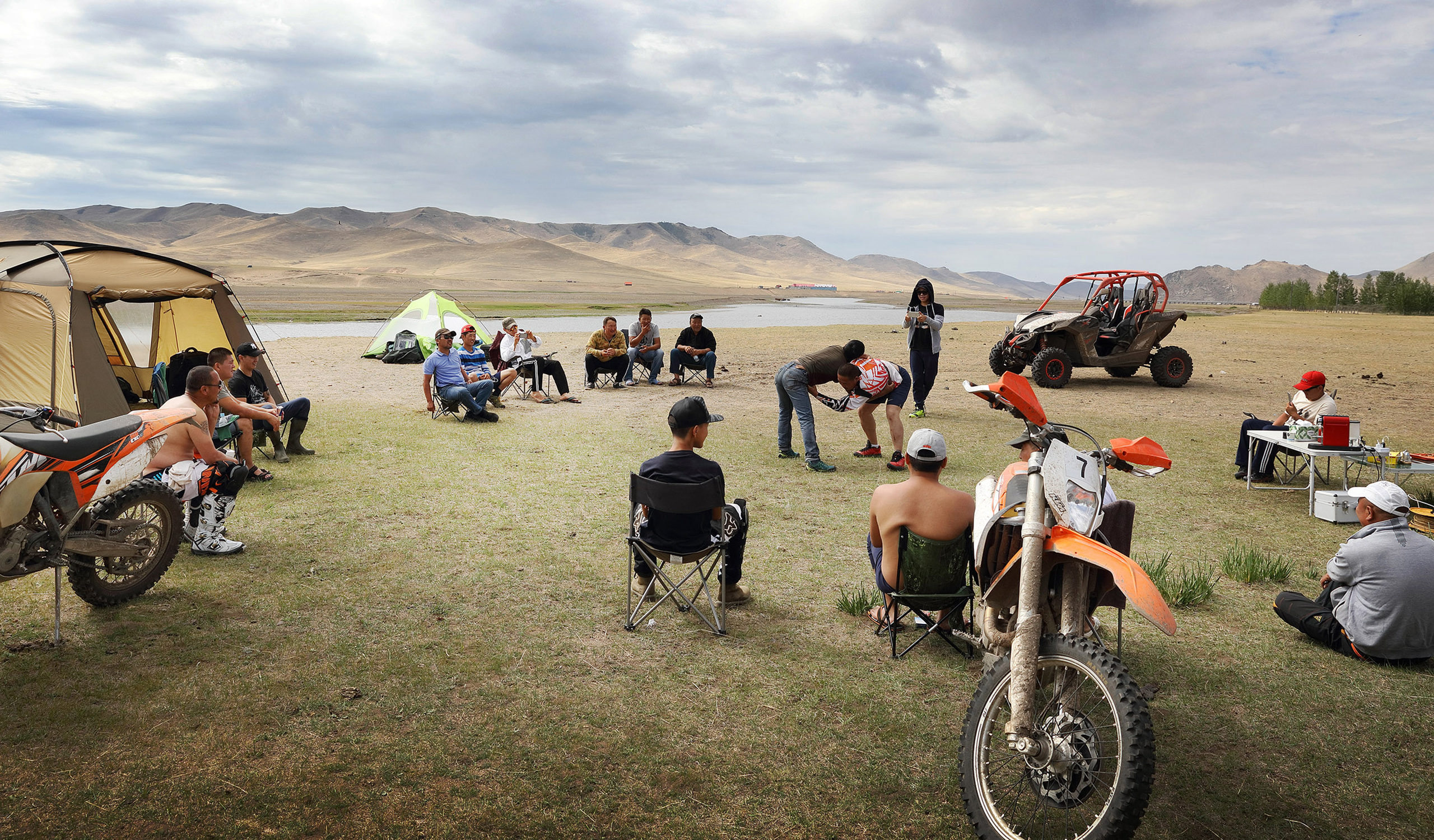 Wrestling is the national sport of Mongolia. A local crew watch on as a couple of friends entertain them.