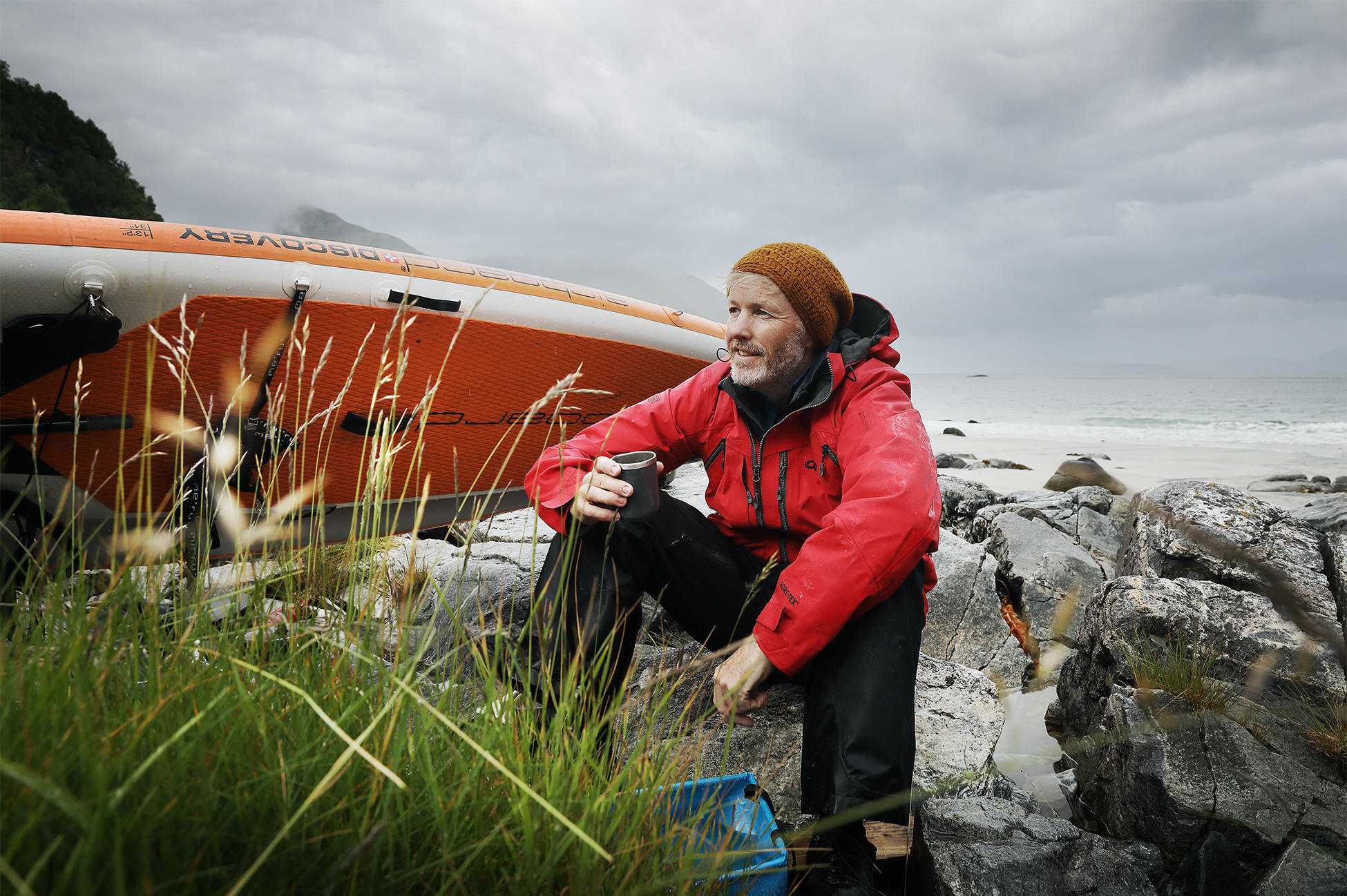 Stand up paddler in Norway under the Midnight Sun taking a break while the weather turns bad